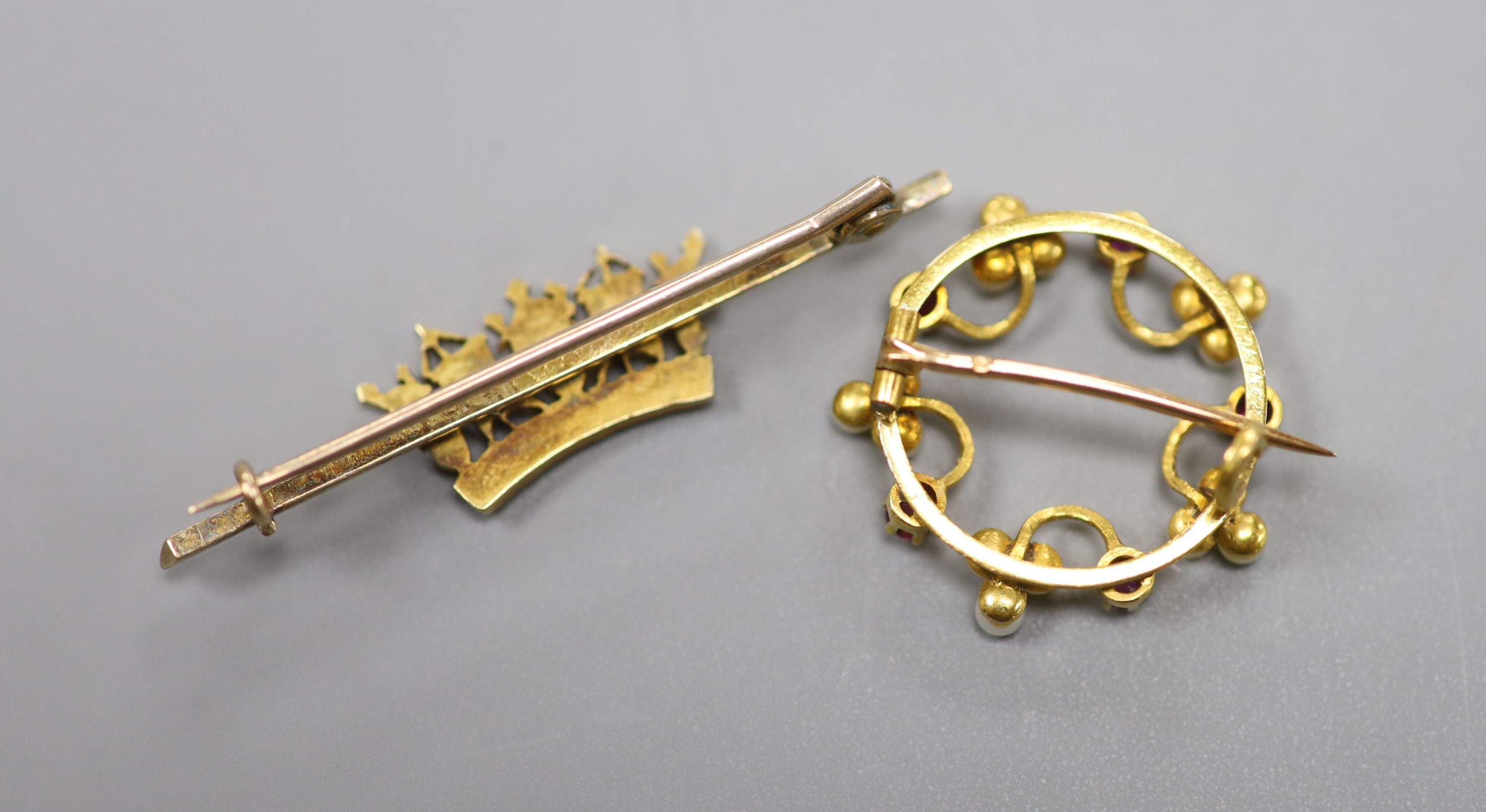 A French yellow metal (18ct poincon mark), seed pearl and ruby set openwork circular brooch, 22mm gross 3.7 grams and a yellow metal and seed pearl set coronet bar brooch, 45mm, gross 4.4 grams.